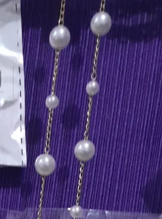 Collar de perlas blancas espaciadas sobre cadena dorada fina